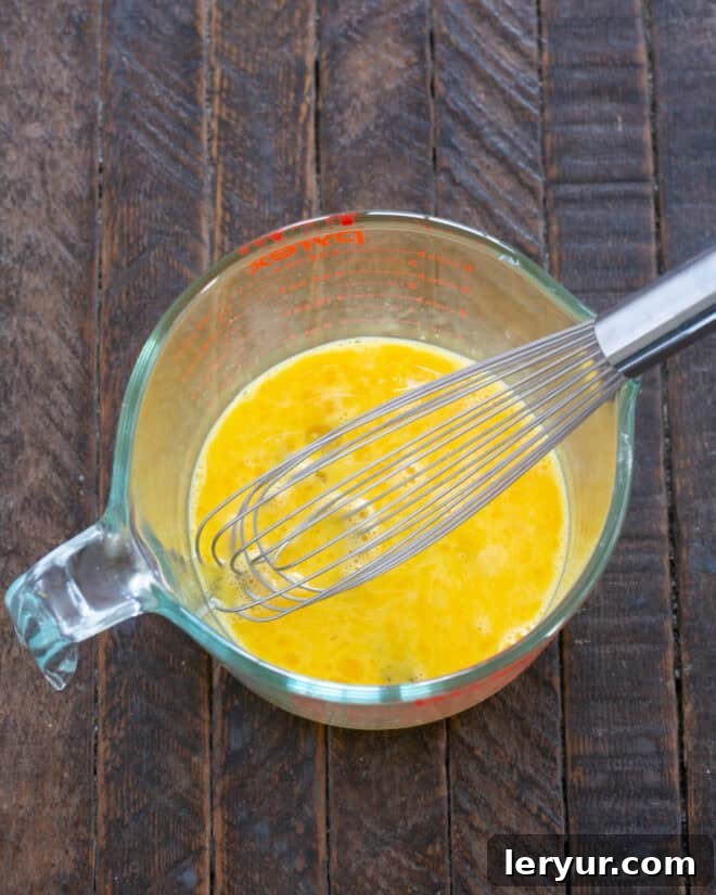 The Secret to Sublime Pumpkin Pie 3 Whisking eggs in a bowl, a crucial first step for the creamy pumpkin pie filling.
