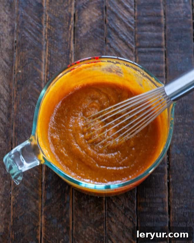 The Secret to Sublime Pumpkin Pie 4 All filling ingredients, including spices and pumpkin, being whisked together in a large bowl.
