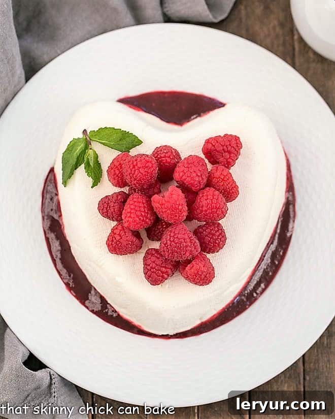Overhead view of Coeur a la Creme with Raspberry Sauce, garnished with fresh berries.