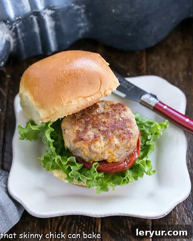 A perfectly assembled Turkey Slider with Roasted Tomatoes on a square white plate, ready to eat.