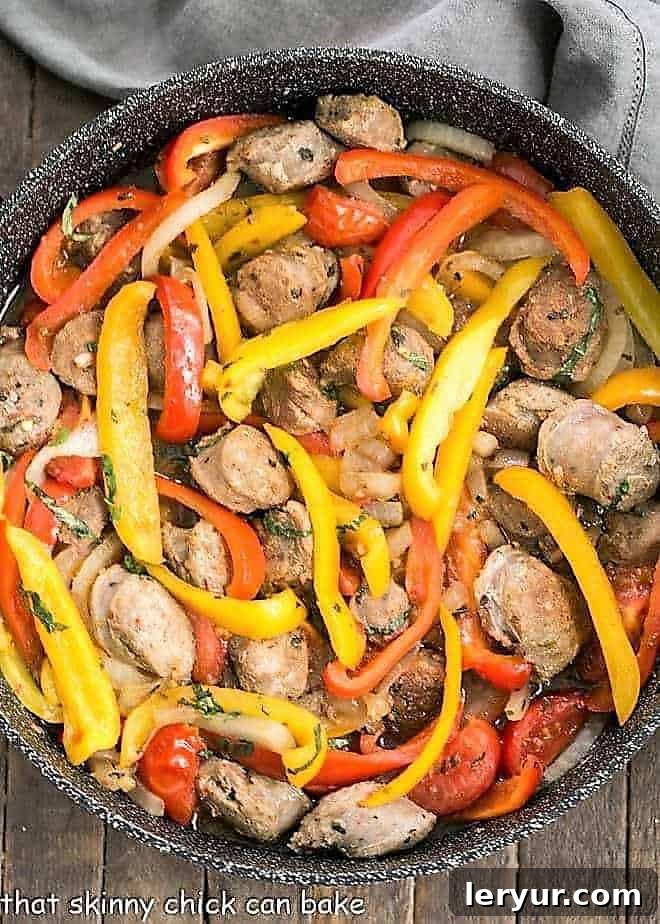 Skillet Italian Sausage and Peppers - a comforting, flavorful meal that's easy to prepare and can be served with Provolone for an unforgettable sandwich! Italian Sausage and Peppers in a black skillet, vibrant with colors and rich flavors
