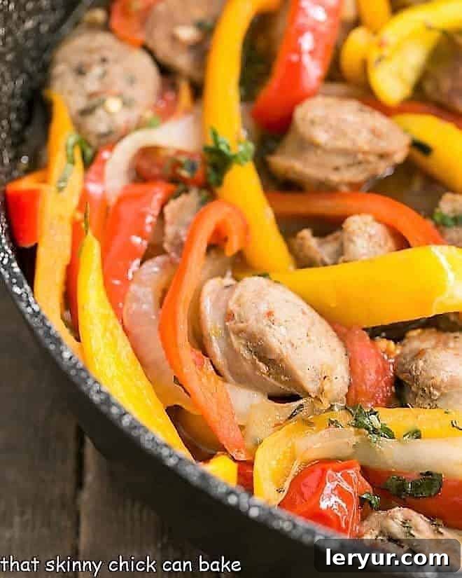 Skillet Italian Sausage and Peppers - a comforting, flavorful meal that's easy to prepare and can be served with Provolone for an unforgettable sandwich! Close-up view of vibrant Italian Sausage and Peppers sizzling in a skillet