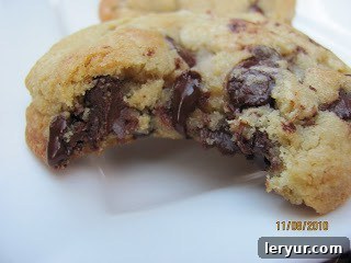 Dangerously Delicious Chocolate Chip Cookies 11 A close-up shot of a single killer chocolate chip cookie, with a perfect bite taken out, revealing its moist, chewy interior and abundant melted chocolate chips.