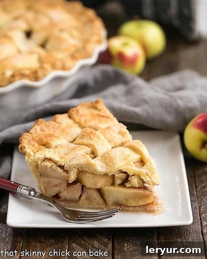 Homemade Apple Pie - A cinnamon spiced apple pie with a flaky lattice crust! A couple tricks make this the best recipe for a classic apple pie! Perfect Apple Pie slice on a square white plate.