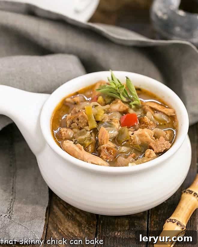 Sausage and Chicken Gumbo - a spicy, flavorful Cajun chicken stew that will warm you to your bones! Sausage and Chicken Gumbo in a ceramic soup bowl