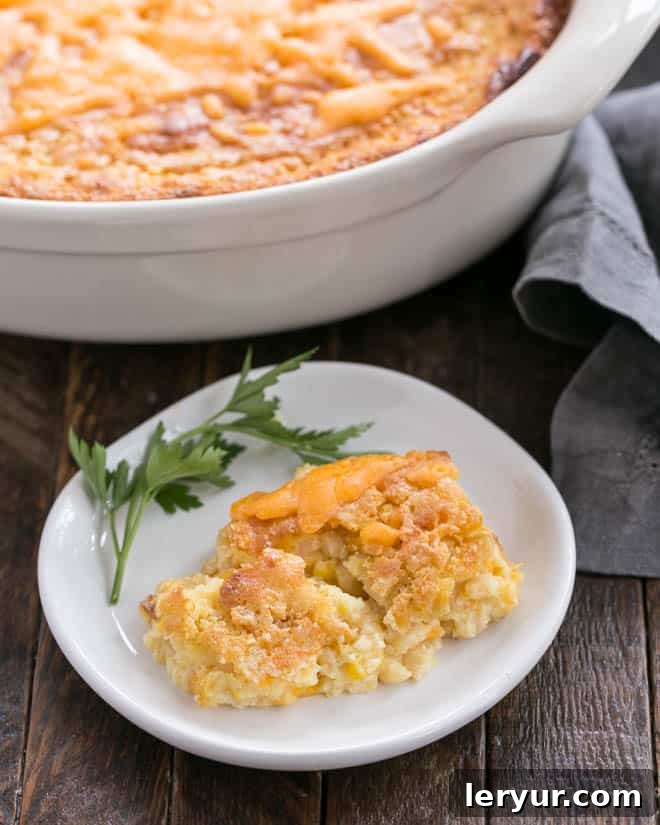 Easy Sweet Corn Casserole - a comforting, simple, and delicious corn pudding side dish, perfect for potlucks, holidays, or any family meal! Easy Sweet Corn Casserole on a small white plate, garnished for serving.