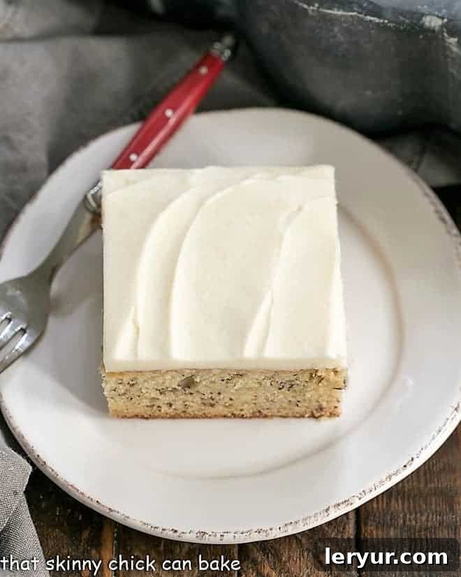 Sour Cream Banana Cake - a tender banana cake topped with a luscious layer of cream cheese frosting! Sour Cream Banana Cake on a round white plate from above.