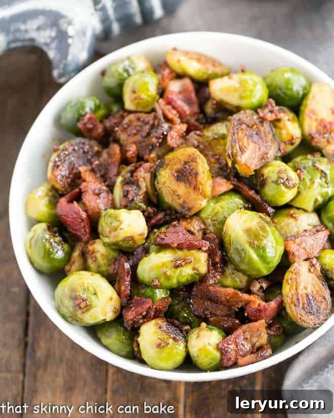 Brussels Sprouts with Bacon Recipe - an autumnal side dish with steamed, then sauteed Brussels sprouts glazed with the bold flavors of grainy mustard, garlic, shallots, real maple syrup and bacon! Maple Syrup Mustard Glazed Brussels Sprouts in a white serving bowl, an autumnal side dish.