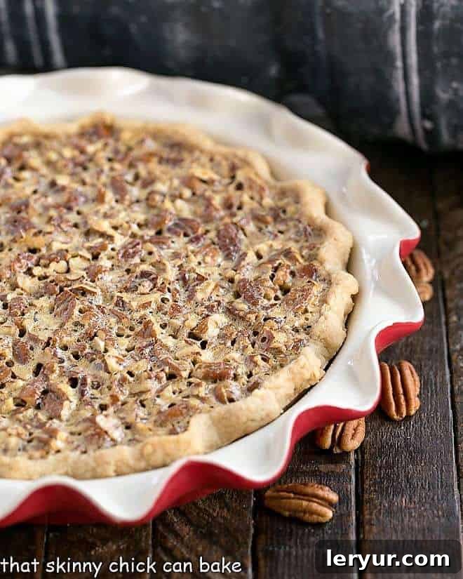 Classic Pecan Pie - a gooey, nutty, decadent holiday pie that is worth every calorie!! Classic Pecan Pie in a red pie plate with pecan halves.