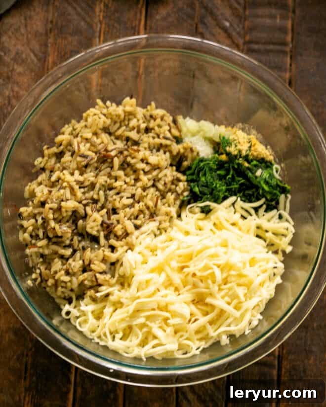 Shredded Monterey Jack cheese and cooked long grain and wild rice added to the bowl.