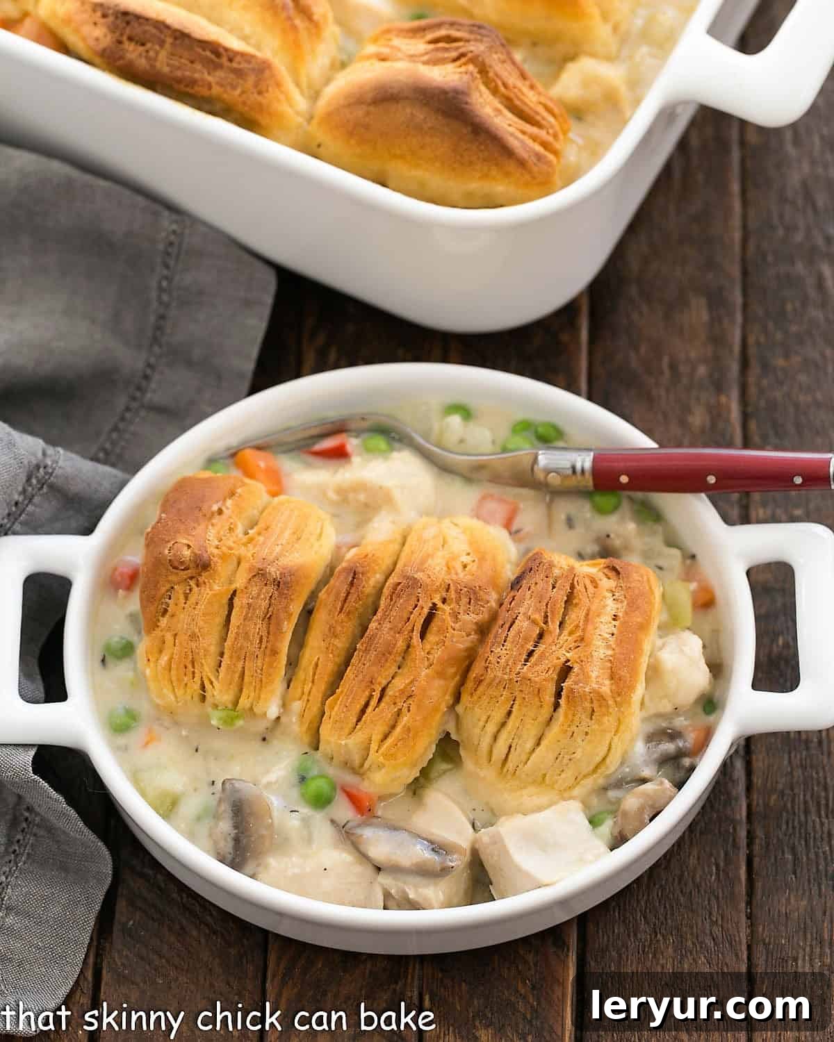 Homemade Chicken Pot Pie - Ultimate Comfort Food A serving of golden-brown chicken pot pie in a shallow white dish, with a red-handled fork resting beside it, ready to be enjoyed.