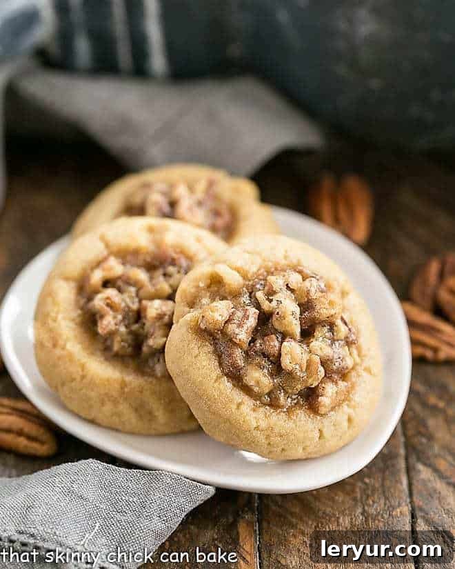 Three pecan pie thumbprint cookies on an oval plate
