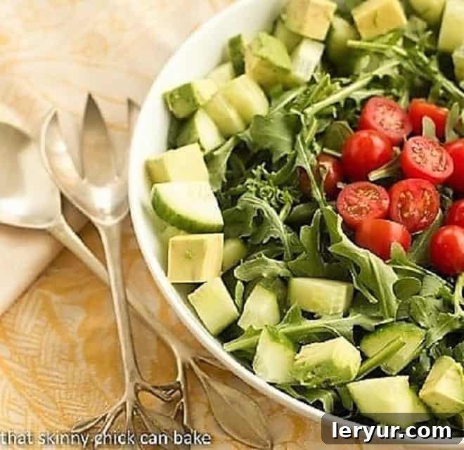 Maddy's Arugula Salad - Fresh produce tossed in a light vinaigrette makes for a fabulous, healthy side dish! Maddy's Arugula Salad presented beautifully in a white ceramic serving bowl, highlighting the fresh ingredients.
