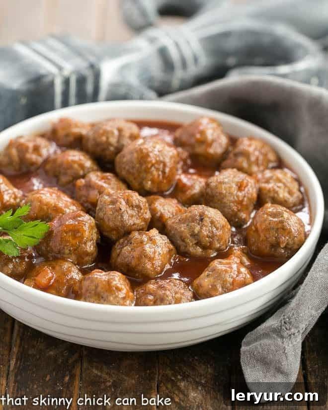 Apricot Glazed Cocktail Meatballs - Delicious meatballs in a sweet and tangy sauce, perfect for all your entertaining needs Apricot Glazed Cocktail Meatballs in a white ceramic bowl with a sprig of parsley