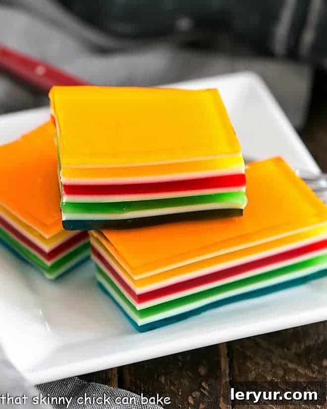Jello Rainbow Ribbon Salad slices on a square white plate, showing perfect layers
