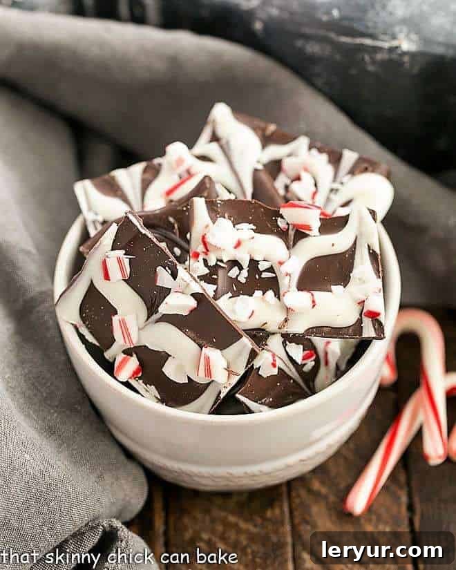 Swirled Peppermint Bark in a white bowl with whole and crushed candy canes for garnish.