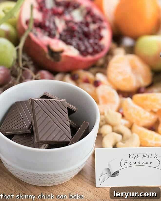 Chocolate Dessert Board with a white bowl of chocolate squares, fruit and nuts