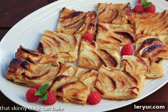 Classic French Apple Tart with a flaky crust on a wooden board.