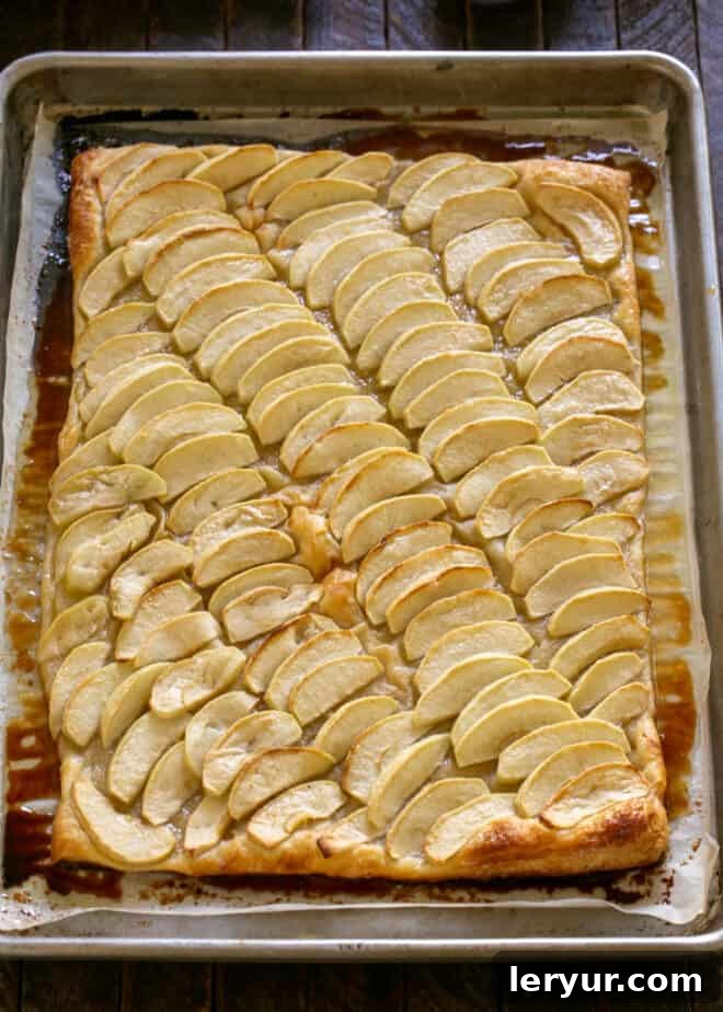 A French Apple Tart baking in the oven, showing the puff pastry rising and apples softening.