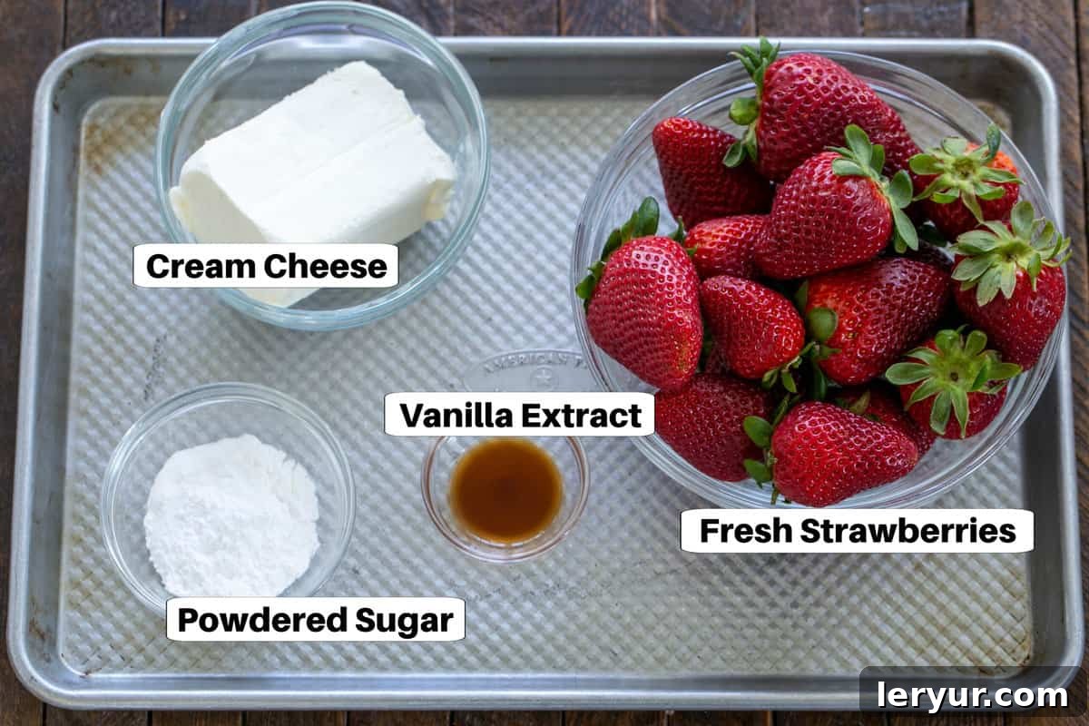Ingredients for Cheesecake Stuffed Strawberries neatly arranged on a metal sheet pan, showcasing fresh strawberries, cream cheese, vanilla extract, powdered sugar, and sliced almonds.