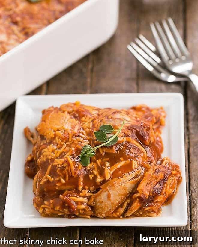 Easy Turkey Enchilada Casserole - super simple casserole with tortillas, turkey, enchilada sauce and cheese for a warm, comforting meal! Serving of Easy Turkey Enchilada Casserole on a white ceramic plate with a fork, showing layers of tortillas, turkey, and cheese