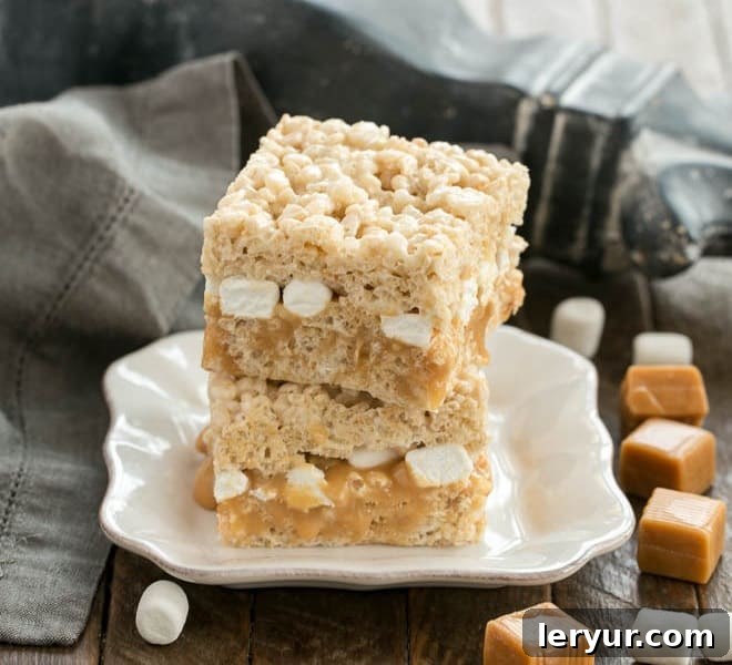Caramel Stuffed Rice Krispie Treats stacked on a square plate.