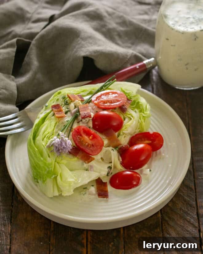 Plating a wedge salad with lettuce, blue cheese dressing, tomatoes, and bacon on a white plate.