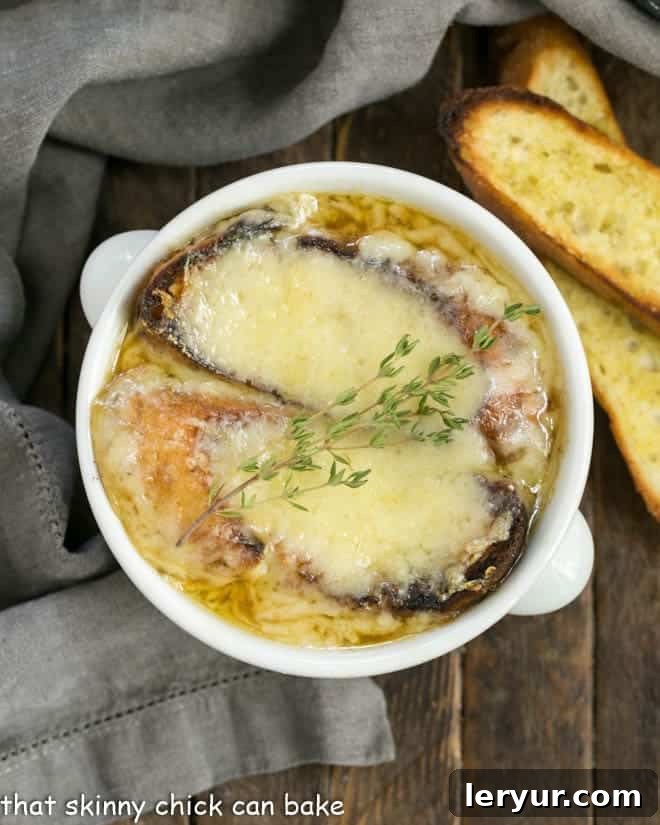 Classic French Onion Soup - A rich onion laden broth flavored with herbs, white wine and cognac and topped with cheesy toast!