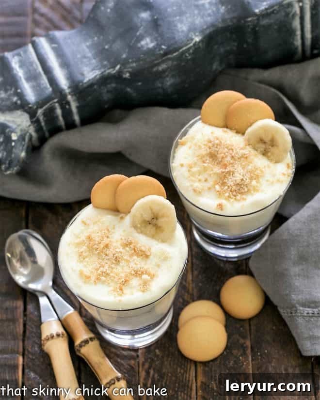 Overhead view of 2 banana pudding parfaits with spoons.