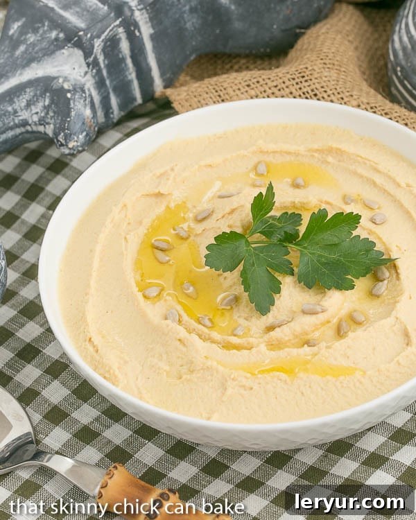 Mims Signature Lebanese Hummus 2 Classic Hummus, lovingly flavored with fresh lemon and robust garlic, presented in a bowl.