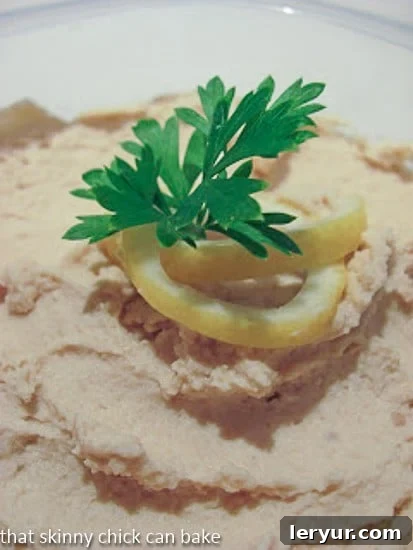 Homemade Classic Hummus Recipe: A vibrant blend of garlic and lemon juice. A close-up view of the rich, creamy texture of homemade hummus.