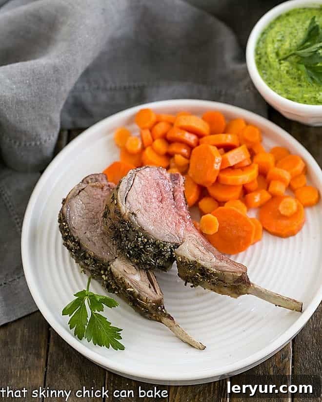 Herb Crusted Rack of Lamb with Parsley Pesto - an elegant, delicious entree for company, Easter dinner or whenever tender spring lamb is available! Herb Crusted Rack of Lamb slices on a white plate with carrot coins.