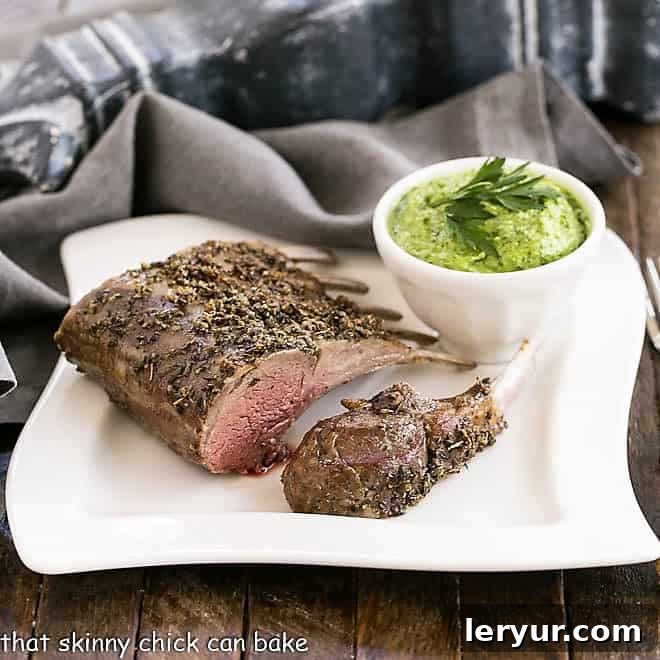 Herb Crusted Rack of Lamb with Parsley Pesto - an elegant, delicious entree for company, Easter dinner or whenever tender spring lamb is available! Herb Crusted Rack of Lamb on a white dinner plate with a bowl of parsley pesto.
