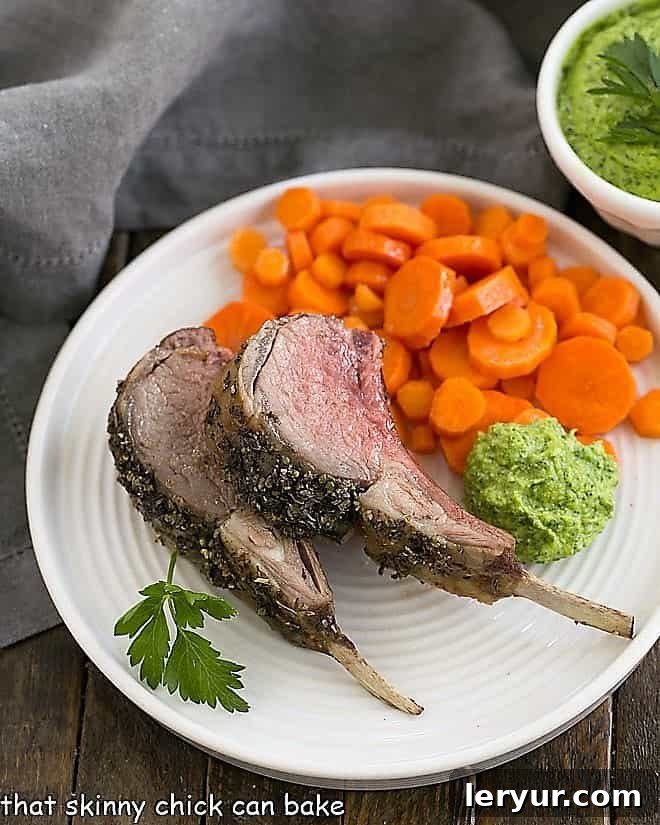 Herb Crusted Rack of Lamb with carrots and parsley pesto on a white dinner plate