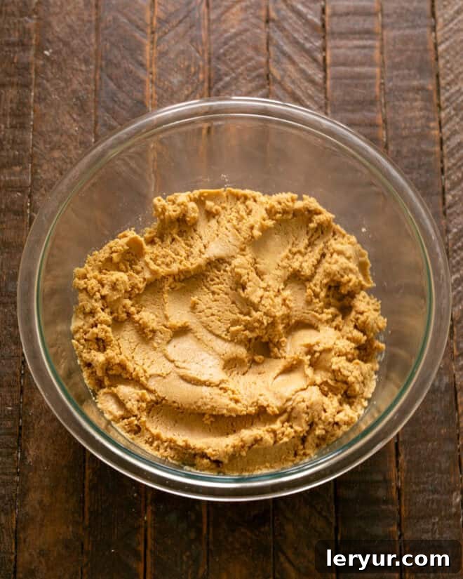Forget Reeses: These Are The Best Peanut Butter Bars 5 Peanut butter mixture being stirred in a bowl until fully combined and cohesive.