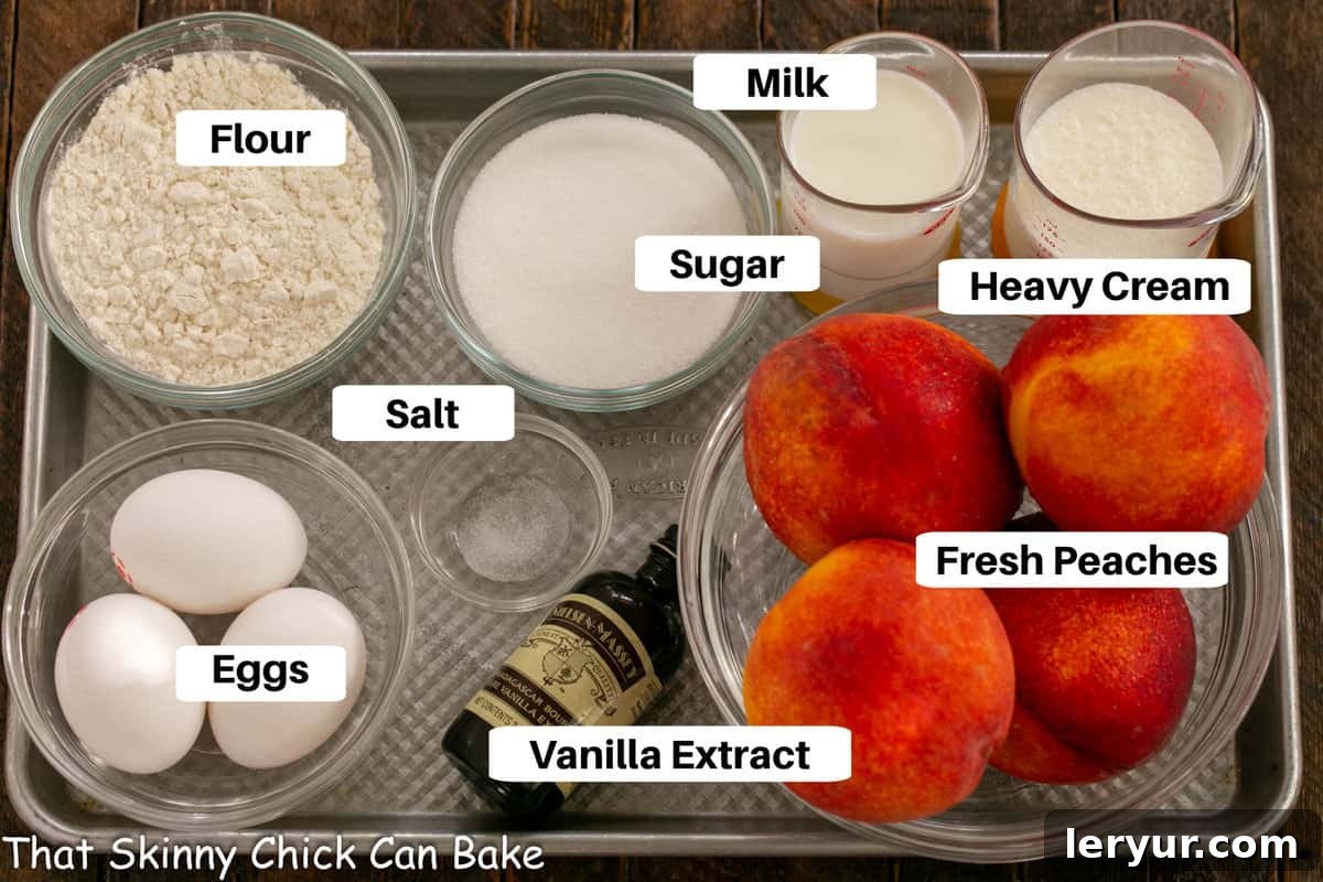 Close-up of fresh peaches, eggs, milk, cream, sugar, flour, and vanilla extract arranged artfully on a metal sheet pan, ready for making clafoutis.