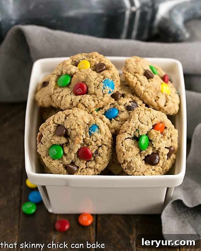 Classic Monster Cookies - chewy peanut butter oatmeal cookies loaded with M&M's, chocolate chips, and walnuts for an irresistible treat! A charming ceramic basket overflowing with freshly baked Classic Monster Cookies, ready to be enjoyed.