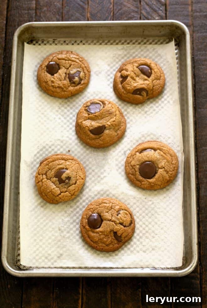 Divine Brown Butter Chocolate Chip Cookies 9 Freshly baked Brown Butter Chocolate Chip Cookies cooling on a sheet pan, showing their golden edges and soft centers.