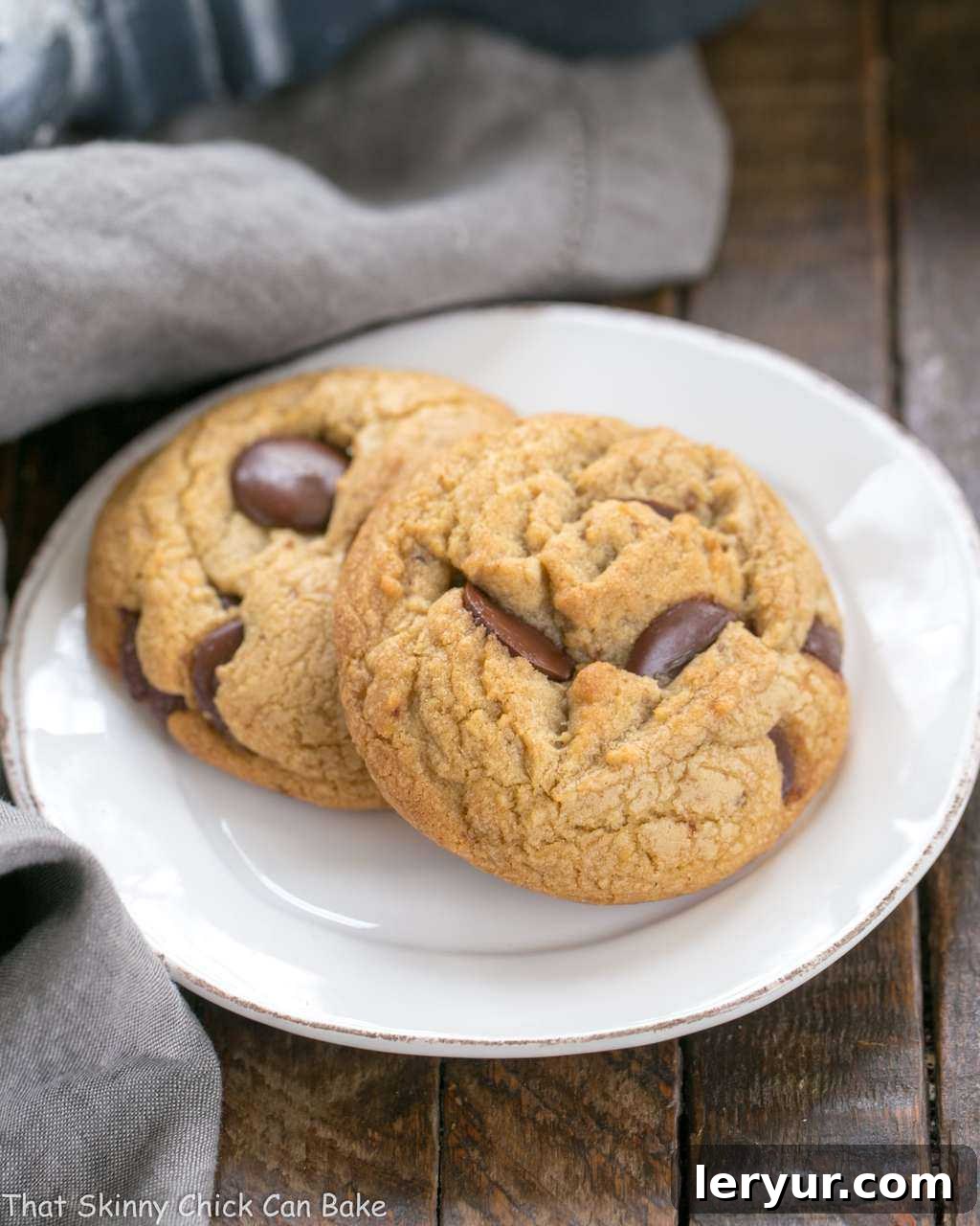 Brown Butter Chocolate Chip Cookies - with a boost of deliciousness from nutty brown butter and dark brown sugar! A beautifully baked Brown Butter Chocolate Chip Cookie, golden-brown with visible melted chocolate, resting on a pristine white dessert plate, ready to be enjoyed.