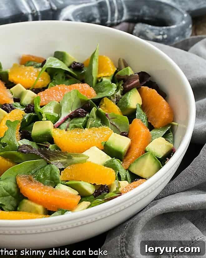 Cherry Orange Salad with Citrus Vinaigrette in a white serving bowl, showcasing vibrant colors and fresh ingredients.