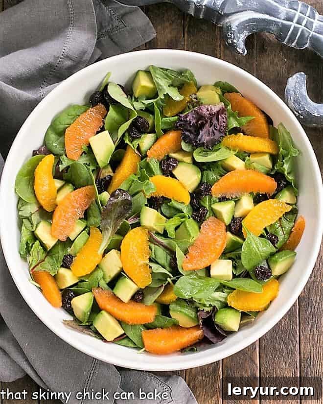 Overhead view of Cherry Orange Salad with Citrus Vinaigrette in a white serving bowl, ready to be served.