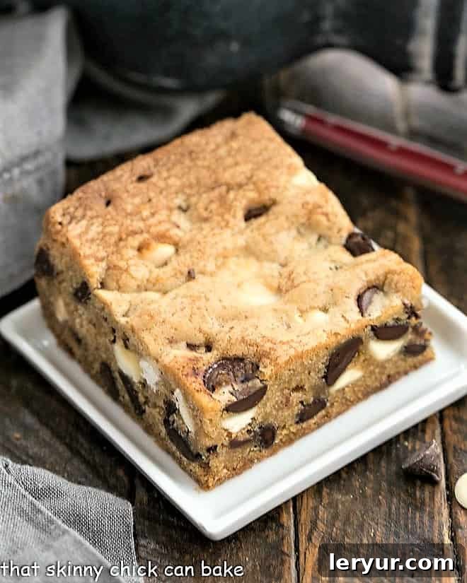 A single delicious Chocolate Chip Cookie Bar presented on a small white ceramic plate, ready to be enjoyed.