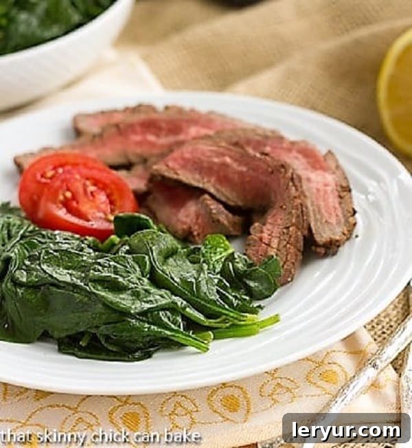 Shake up your side dishes with this super easy, tasty lemon steamed spinach recipe Easy Lemon Spinach with flank steak on a white plate