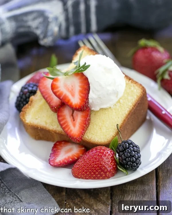 A perfectly sliced piece of the Best Pound Cake, topped with vibrant fresh berries and a dollop of whipped cream, showcasing its beautiful, dense crumb.