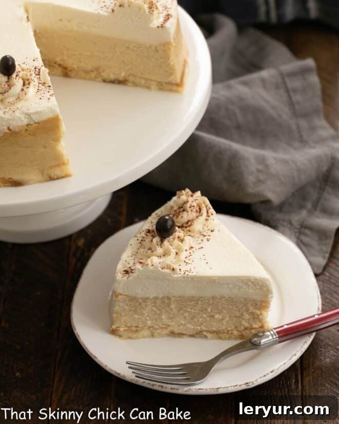 Tiramisu cheesecake - with coffee soaked ladyfingers, coffee flavored cheesecake and a luscious mascarpone topping, this is one dreamy layered dessert! A perfect slice of Tiramisu Cheesecake on a white dessert plate, with the remaining cake in the background.