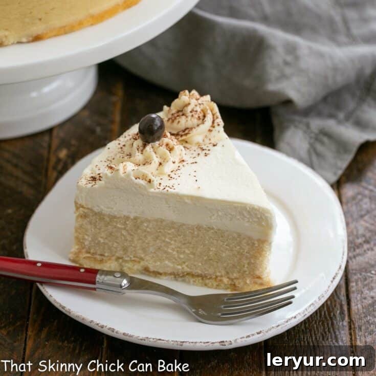 Slice of Tiramisu cheesecake on a white dessert plate with a red handled fork, showing the distinct layers.