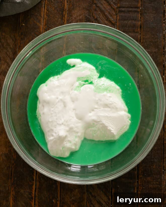 Emerald Oasis Oreo Dream 5 Step-by-step image illustrating marshmallow creme, milk, and creme de menthe being combined in a bowl.