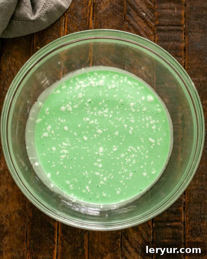 Emerald Oasis Oreo Dream 6 Step-by-step image of ingredients being combined with a hand mixer until smooth.