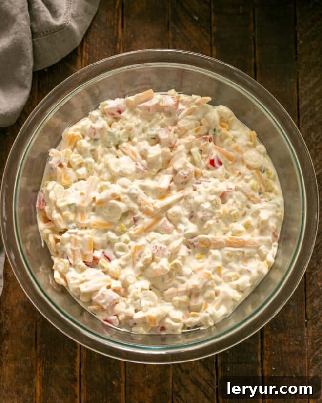 Mixing together the dressing and other ingredients for corn dip.