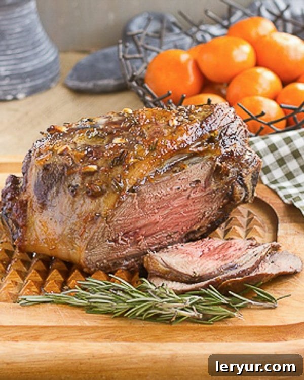 Glazed Leg of Lamb with Garlic and Rosemary on a cutting board, ready to be served.